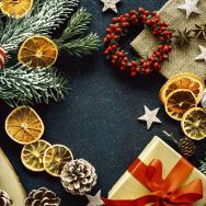 Servietten mit dunklem Hintergrund und Dekorationen zu Weihnachten wie Geschenke und Zweige